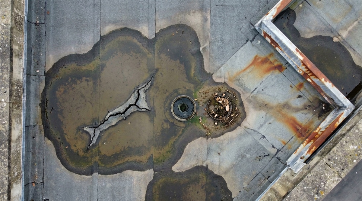 Aerial view of a commercial flat roof with ponding water