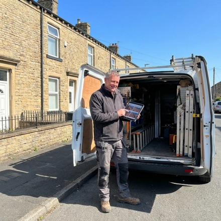 A roofer at a work van on a northern street